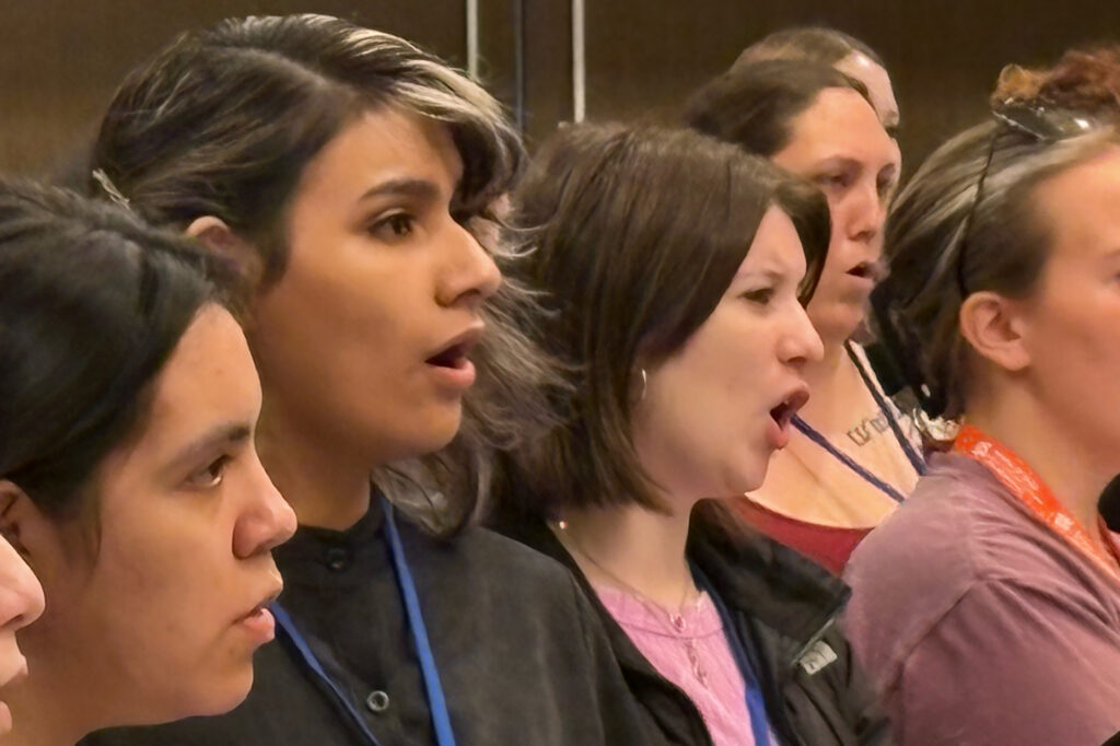 Singers in the soprano and alto sections during rehearsal